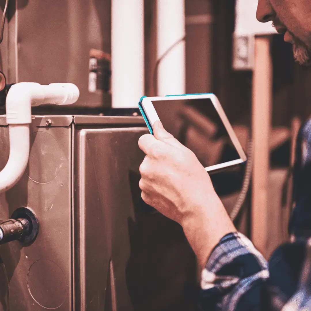 Hawana technician performing seasonal furnace check and recording data on a tablet.