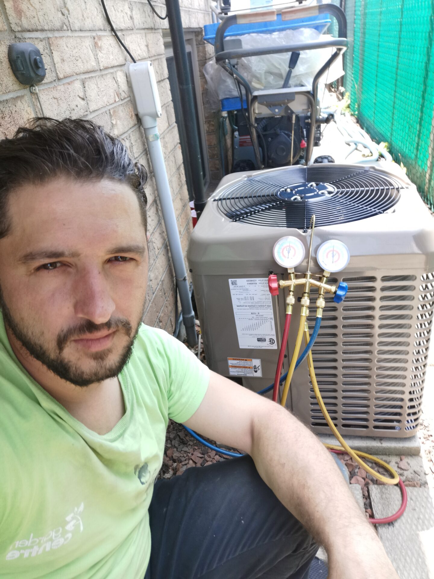 Abdullah Ghzail, HVAC specialist and owner of Hawana HVAC Solutions, performing air conditioner diagnostics with manifold gauges.