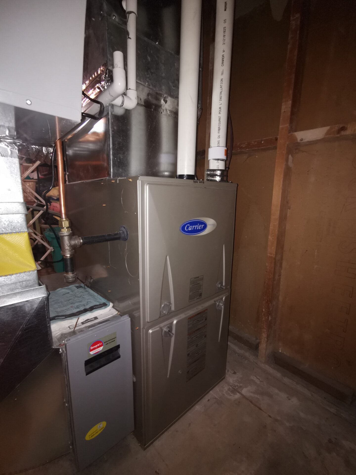 A professionally installed high-efficiency Carrier gas furnace in a residential utility space.