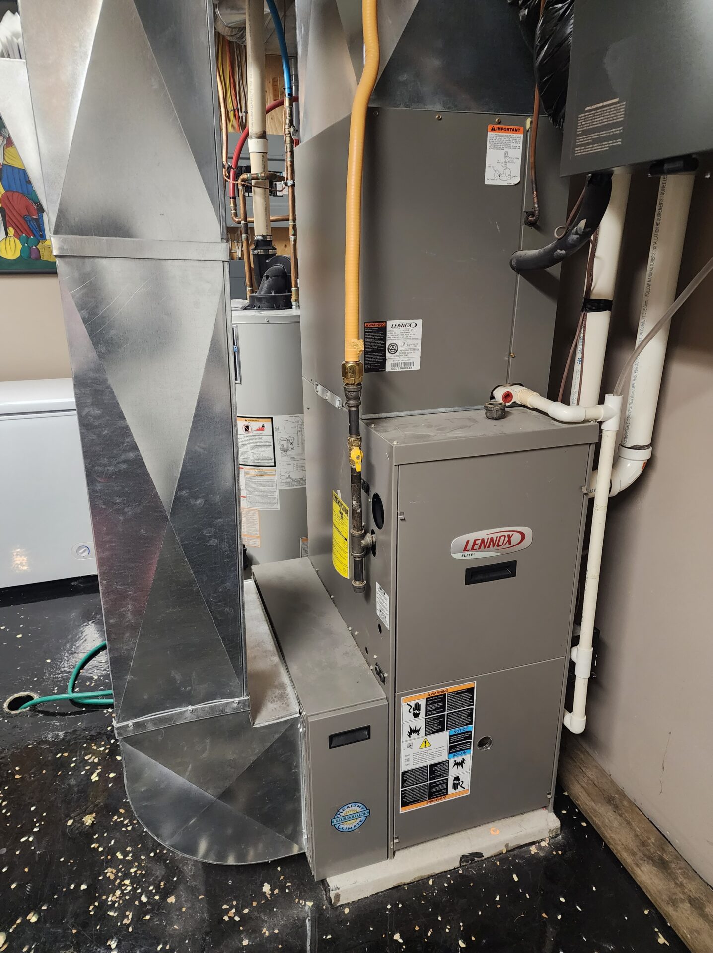 A neatly installed Lennox Elite series high-efficiency gas furnace in a residential basement.